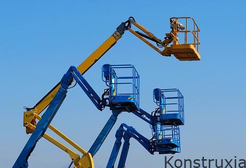 Work aerial platforms against blue cloudless sky. One cherry picker yellow among three blue .